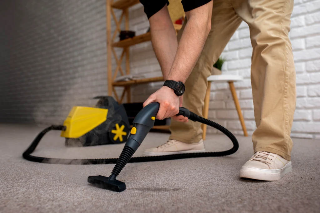 Professional cleaner using a steam vacuum to clean carpet